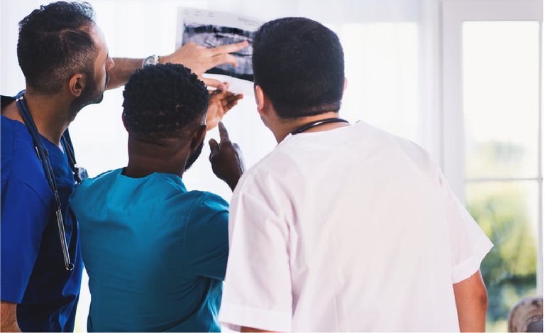 three physicians looking at x ray